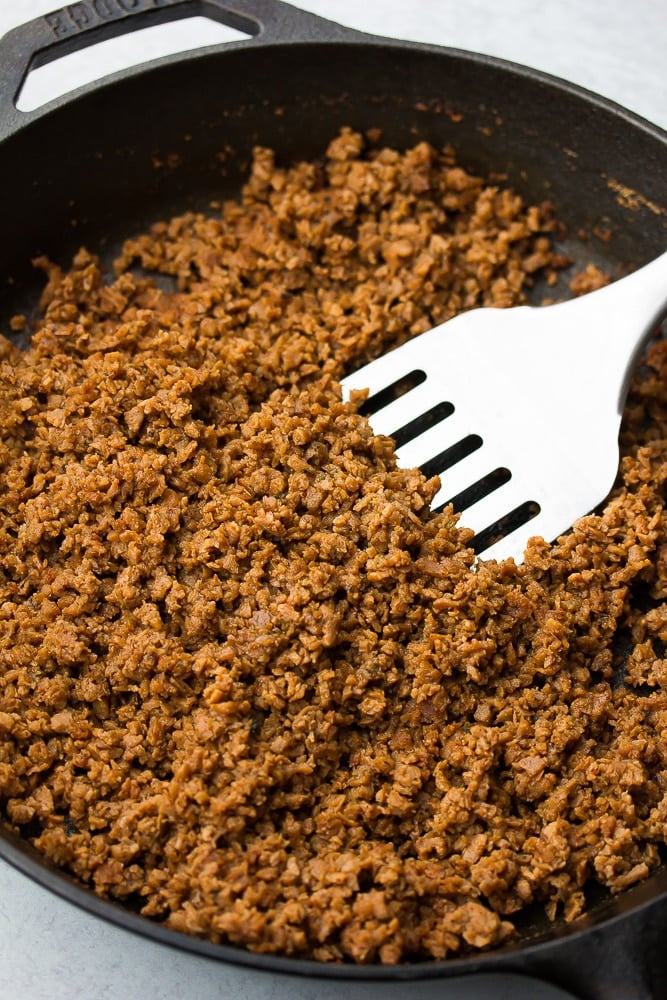 vegan ground taco beef in a black pan with a spatula