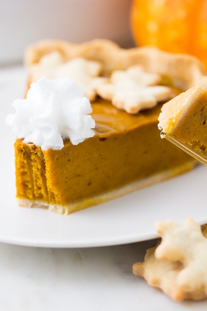 close up photo of a bite taken out of vegan pumpkin pie slice