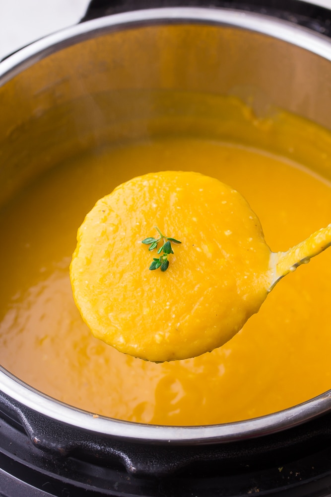 ladle of butternut squash soup being lifted out of pot