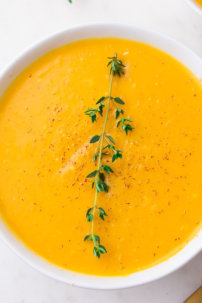 close up of a bowl of instant pot butternut squash soup with thyme