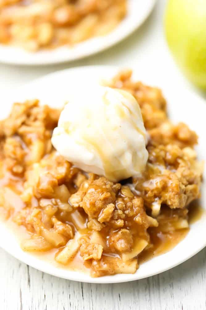 two plates with apple crisp with ice cream on top
