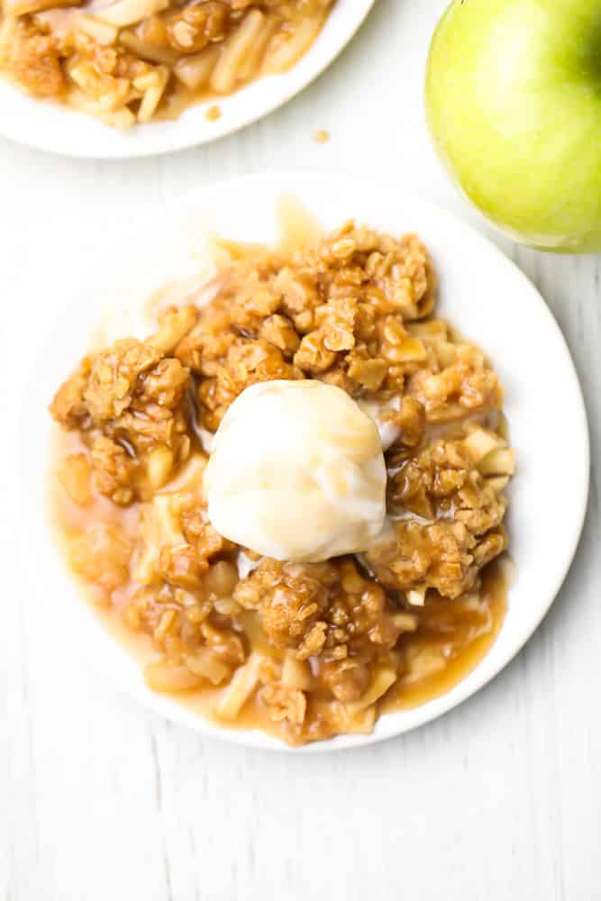 looking down on two plates of apple crisp with ice cream