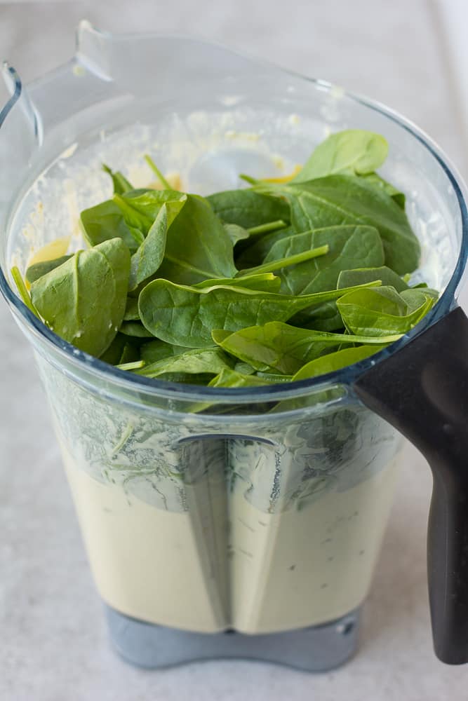 Adding spinach and artichokes to sauce for vegan spinach artichoke dip