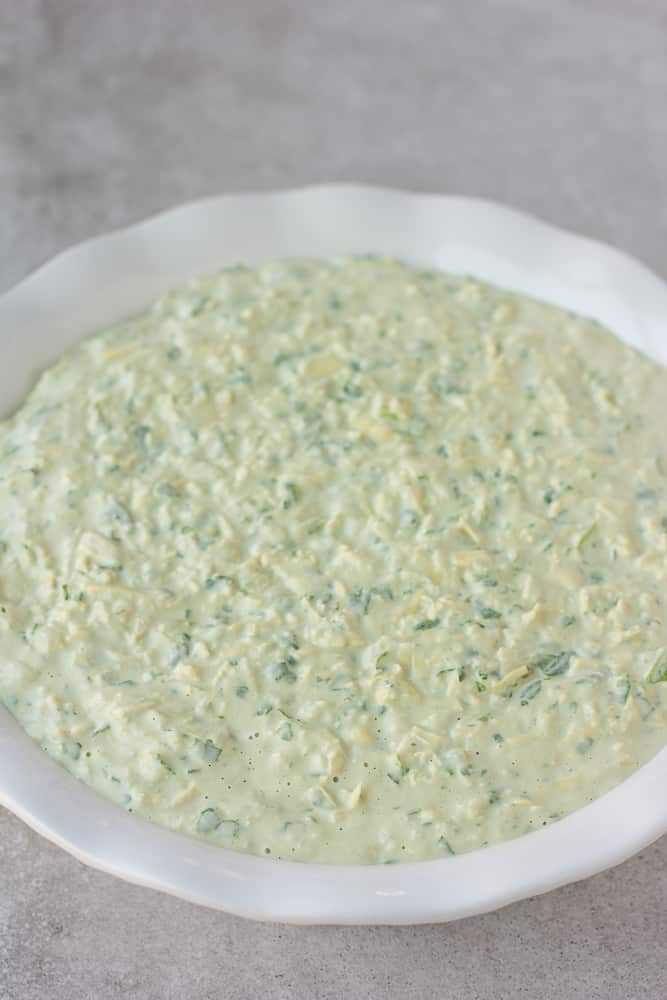 uncooked vegan spinach artichoke dip in a pan