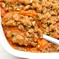 square image of casserole dish with sweet potatoes and pecan topping