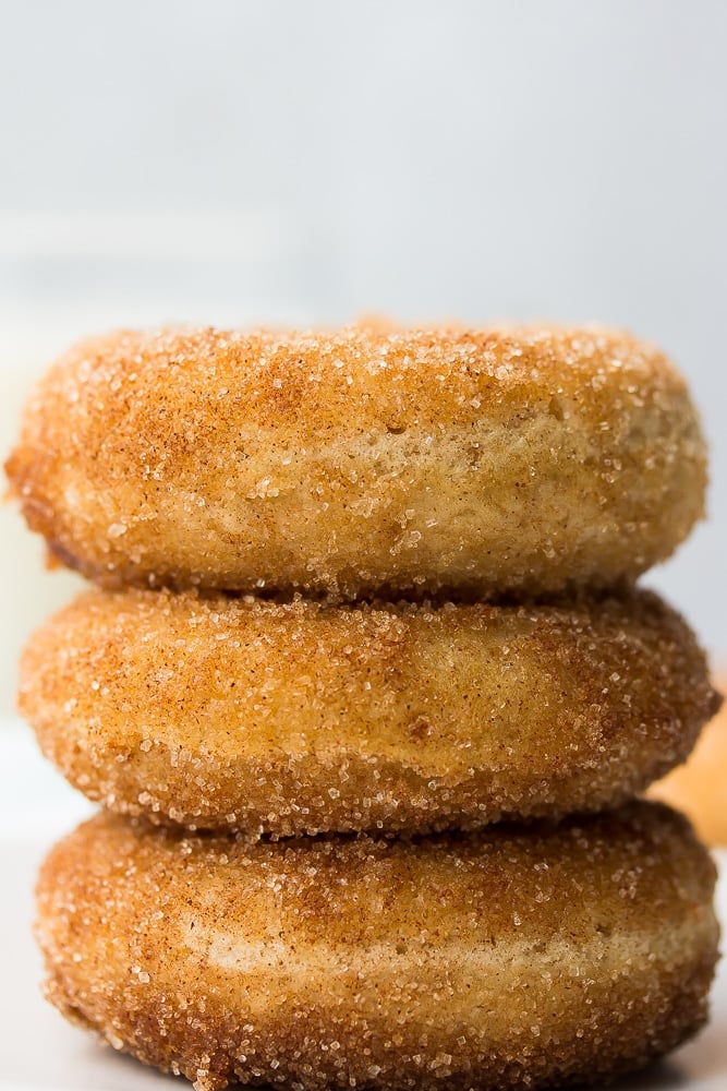 close up of 3 donuts stacked, grey background