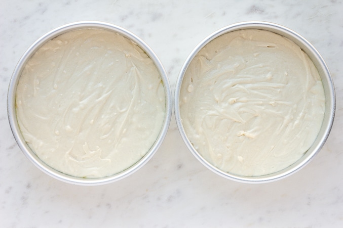 2 pans with uncooked vegan vanilla cake 