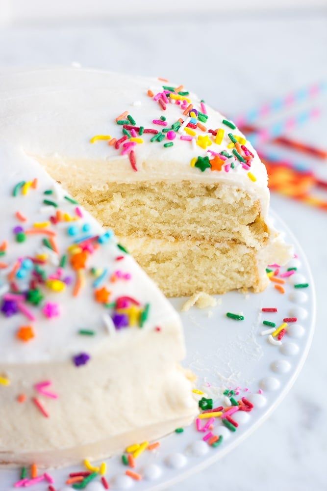 vegan vanilla cake with sprinkles on a cake plate