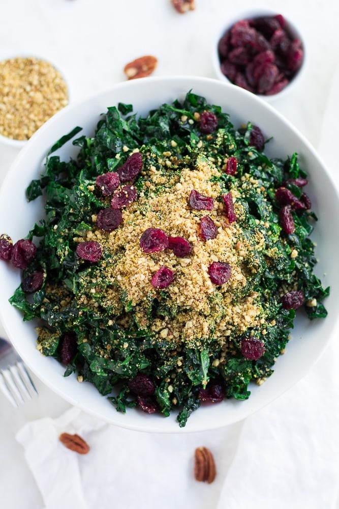 looking down on festive kale salad in white bowl