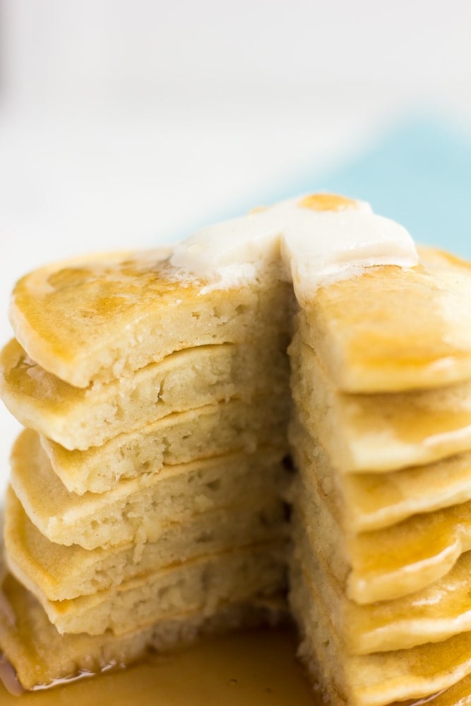 stack of vegan pancakes with a large piece cut out, showing insides