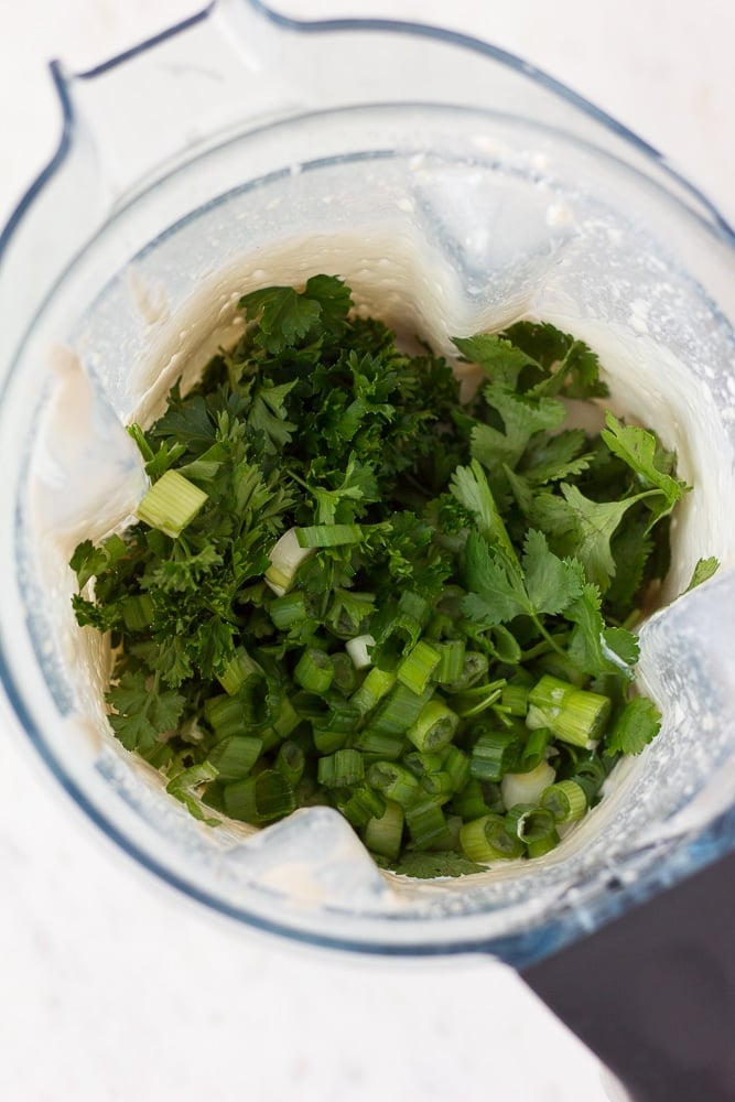 fresh herbs added for green goddess dressing to blender.