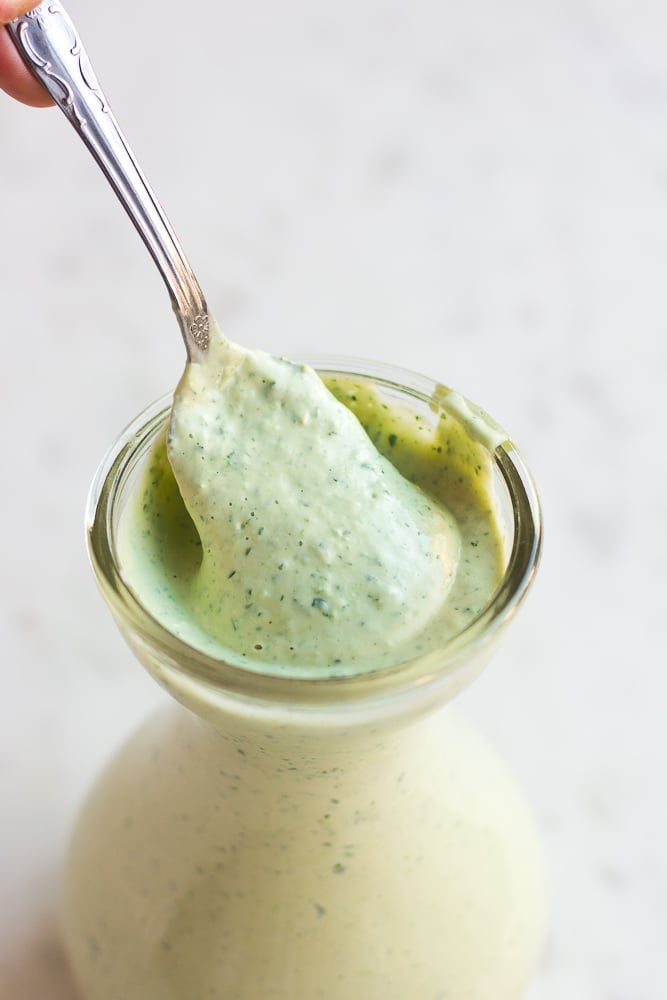 vegan green goddess dressing in a dish with a spoon.