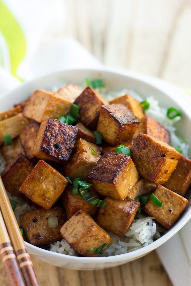 marinated tofu in a bowl with rice and green onions