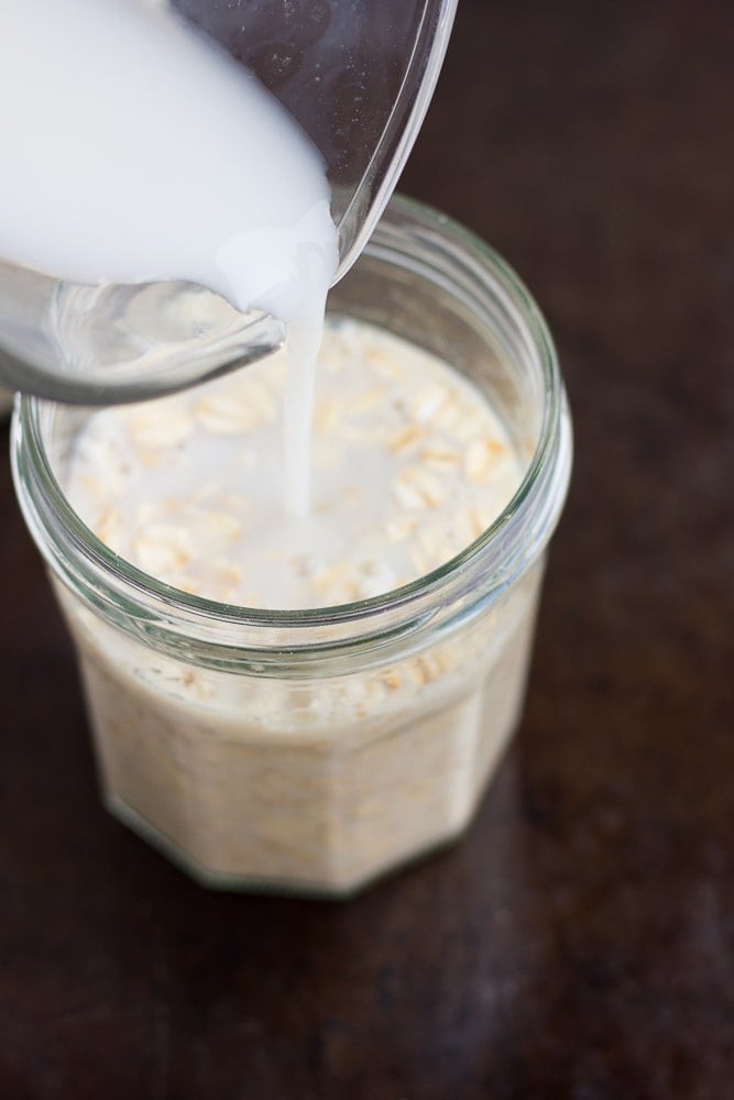 non-dairy milk being poured into jars with oats