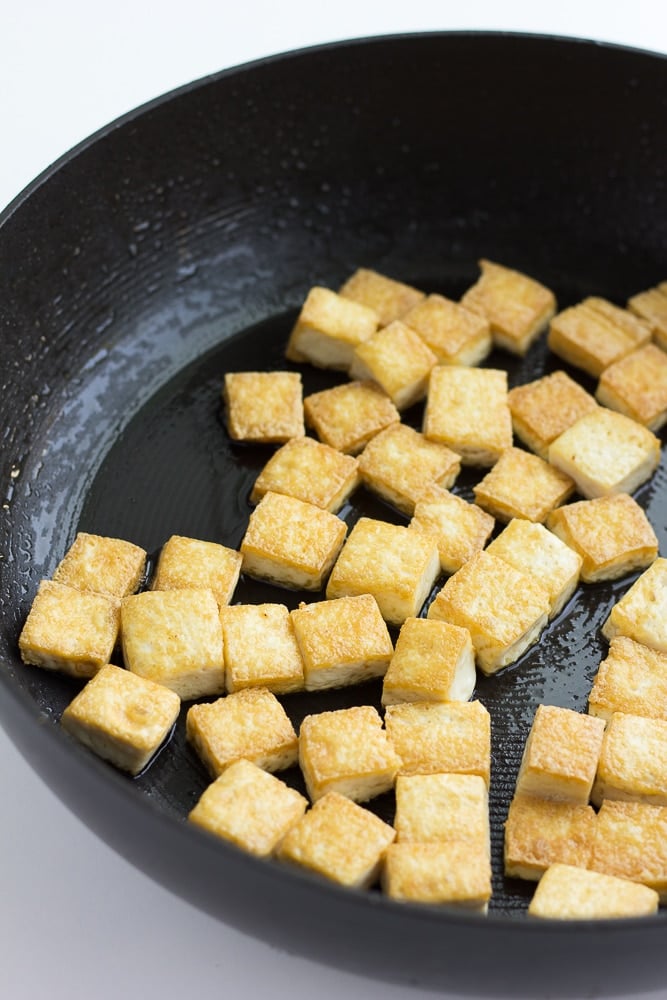 tofu frying in a large pan