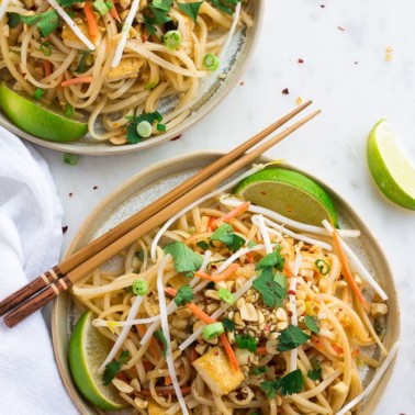 two plates with vegan pad thai from top with chopsticks
