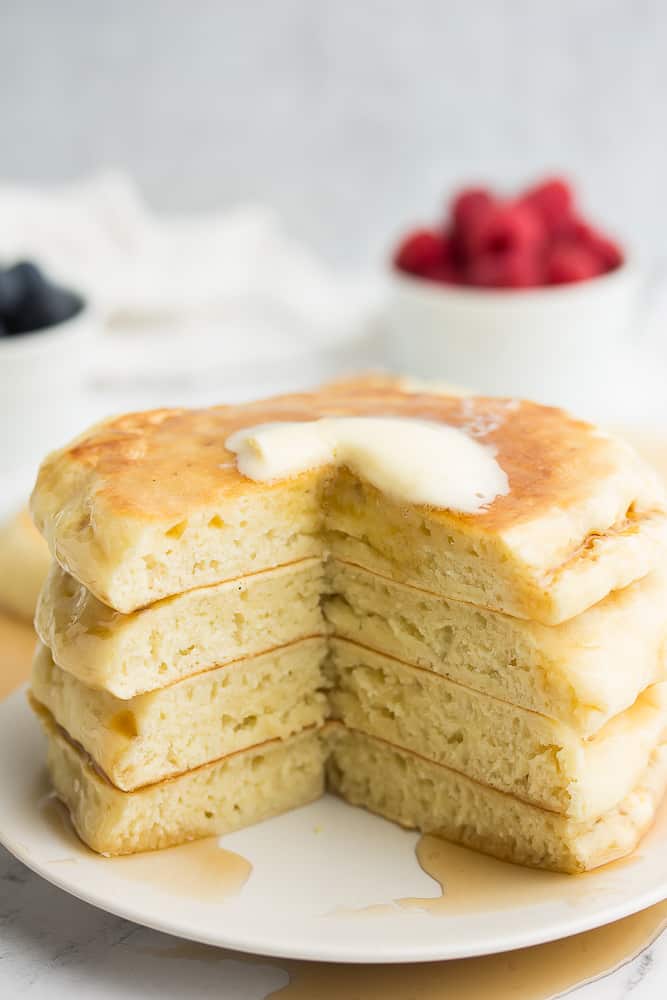 stack of pancakes with a slice taken out, showing fluffy texture inside