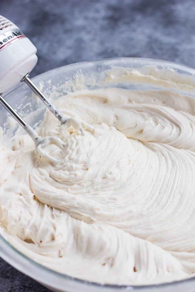 vegan cream cheese frosting in a bowl with a mixer, thick.