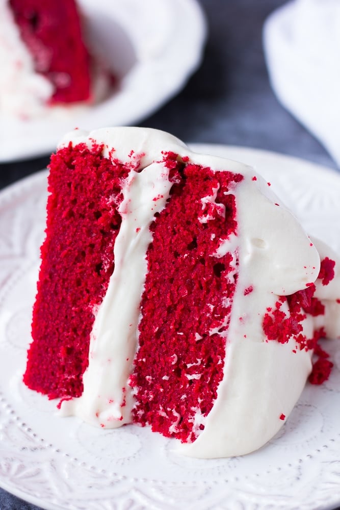 slice of vegan red velvet cake on a plate, close up.