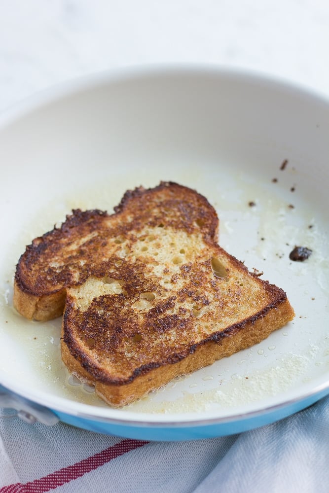 vegan french toast being cooked in a pan.