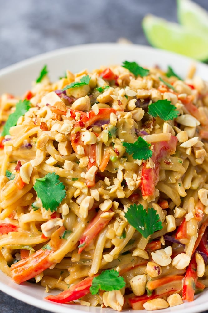 high plate of thai peanut noodles in white dish.