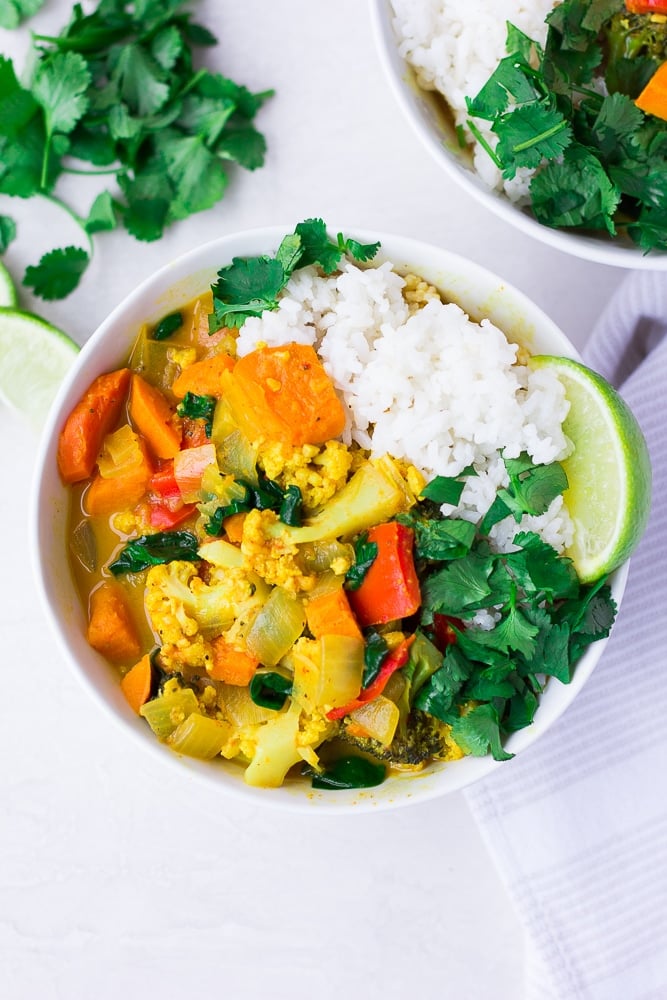 looking down on vegan curry with rice, cilantro and limes.