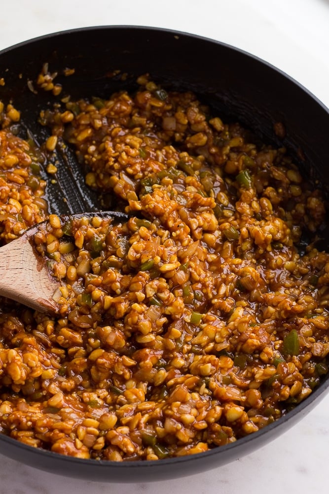 bbq tempeh in a pan with a spoon, cooked.