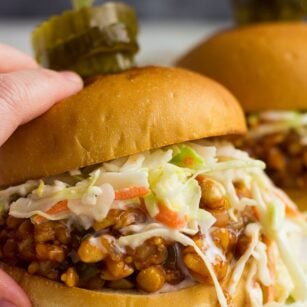 hand holding bbq tempeh sandwich