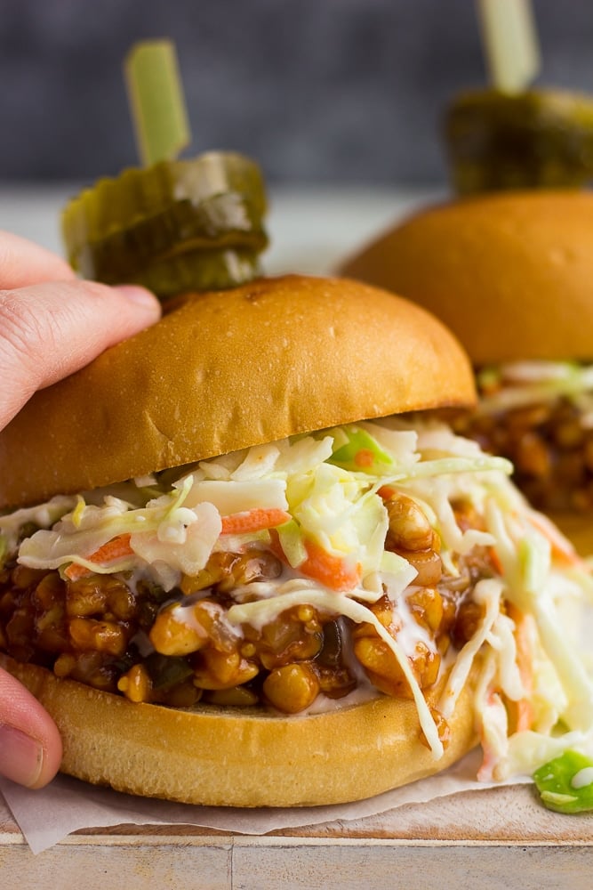 hand holding bbq tempeh sandwich