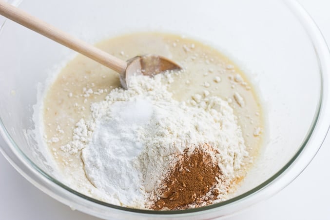 adding dry ingredients to wet in a bowl.