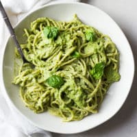 square image of pesto with noodles in a bowl