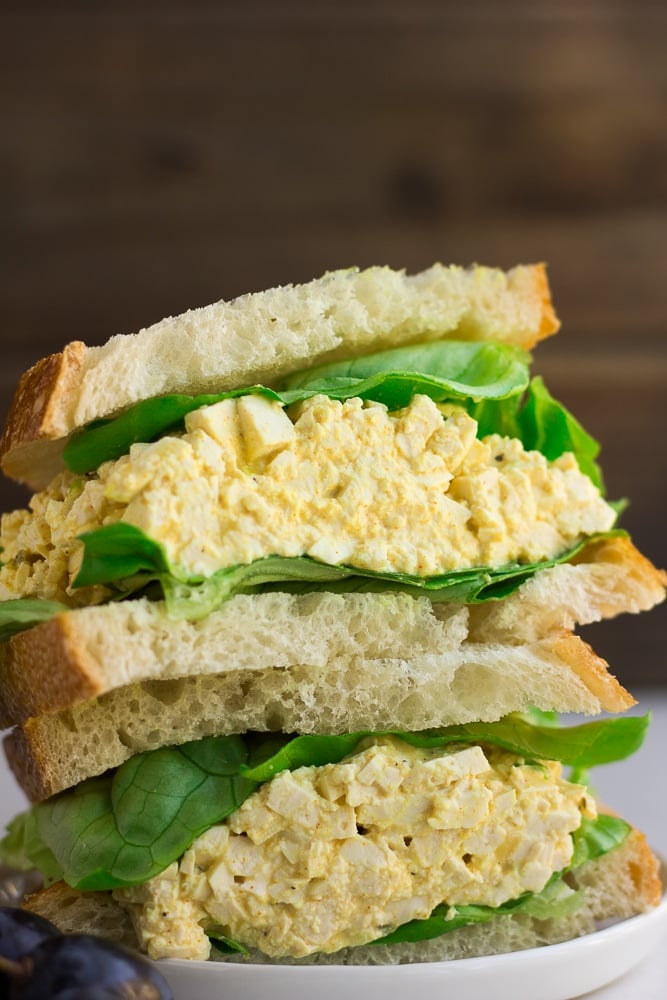 close up of vegan egg salad in a sandwich with lettuce.