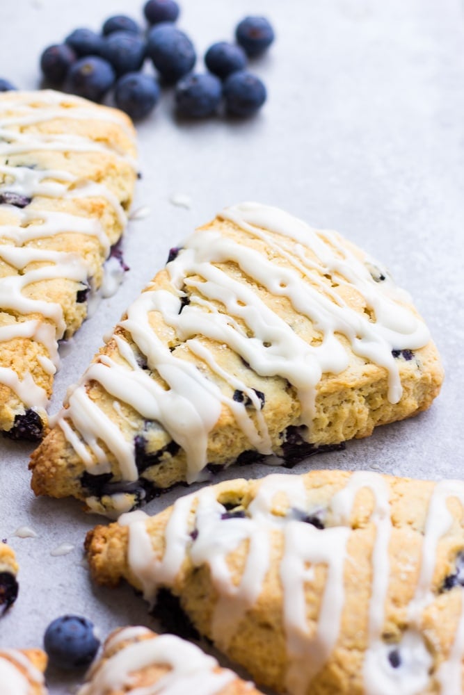 a couple of blueberry scones with glaze, grey background