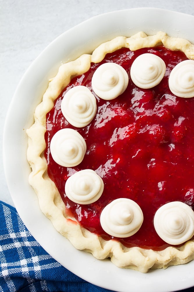 whole vegan strawberry pie, white background, with whip cream.