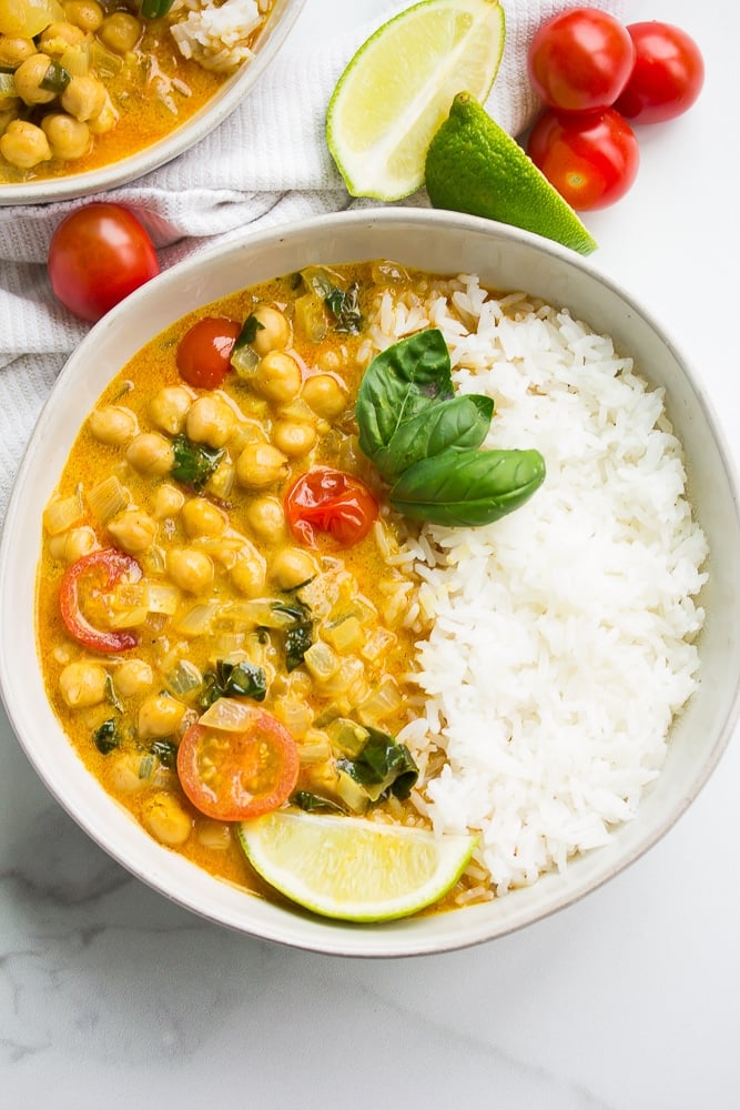 chickpea curry in a white bowl with rice.