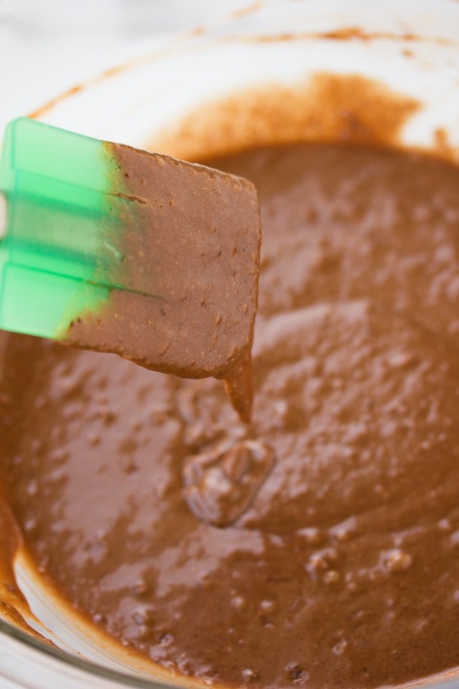 chocolate batter in a bowl with a green spatula