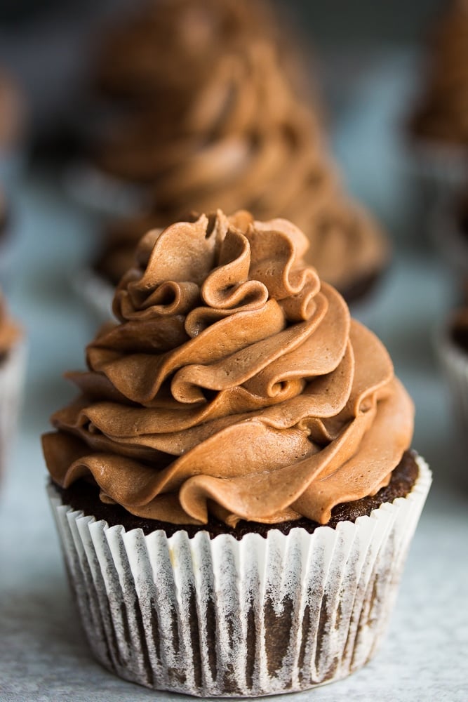 close up of chocolate cupcake with white liner