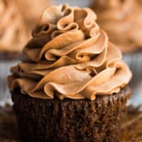 square image of a close up chocolate cupcake with a lot of swirled frosting on top
