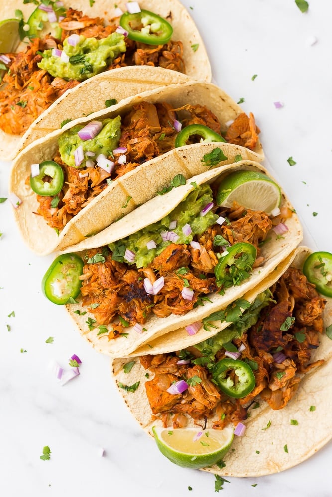 carnitas tacos lined up in a row