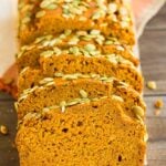 sliced pumpkin loaf with brown wood background and orange towel