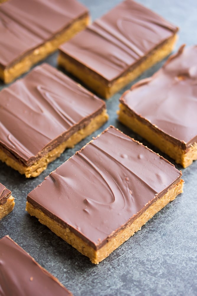 side shot of chocolate peanut butter bars with black/grey background