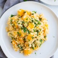 risotto with squash and spinach on a white plate