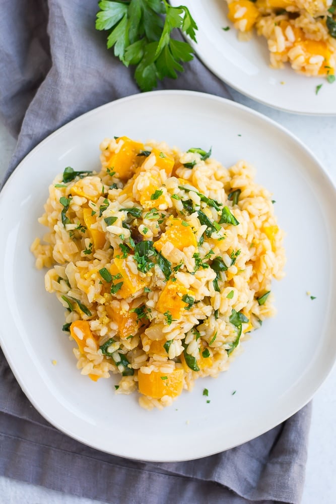 risotto met pompoen en spinazie op een wit bord