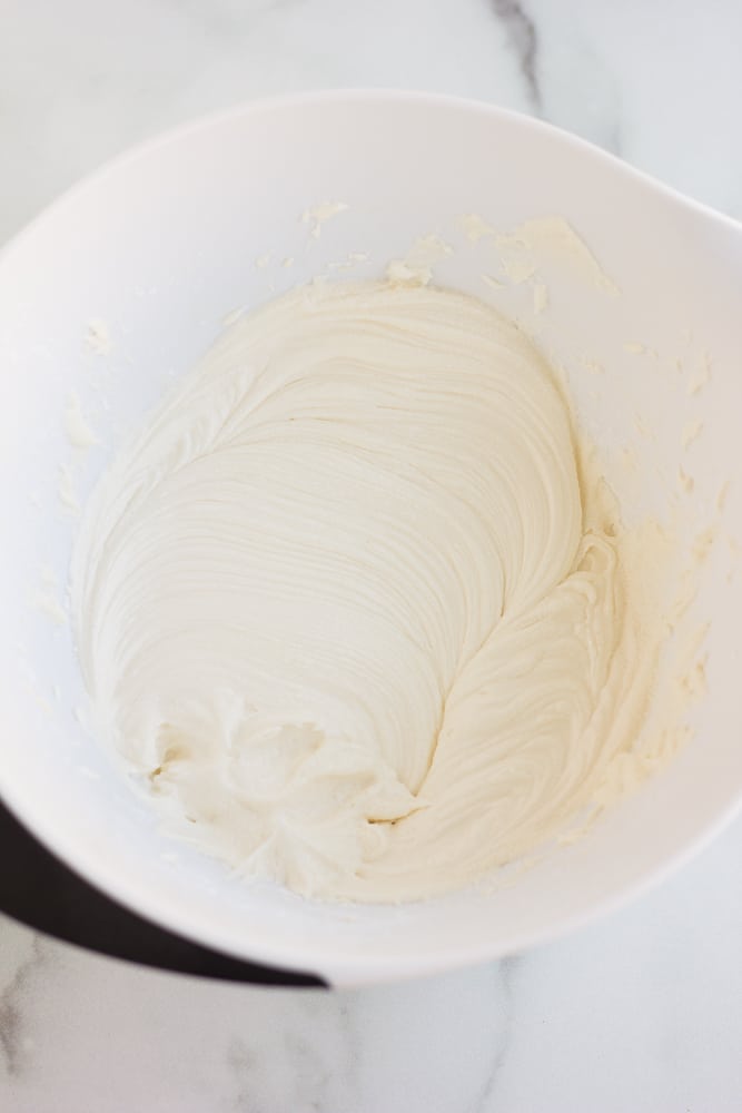 the white frosting for pumpkin cookies in a bowl, whipped.