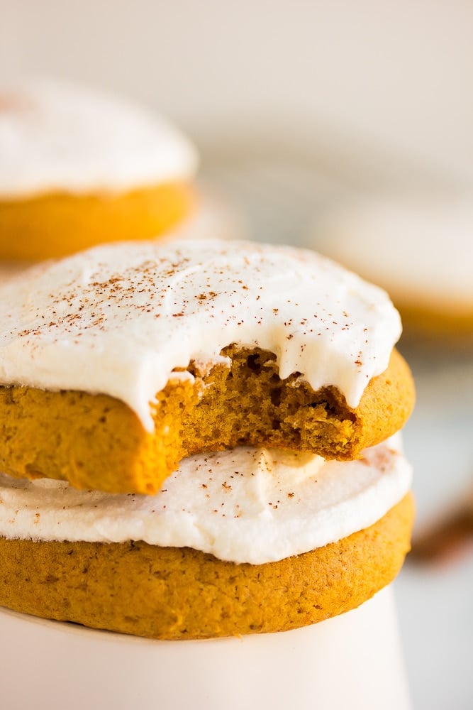 close up of a vegan pumpkin cookie with a bite taken out of one.