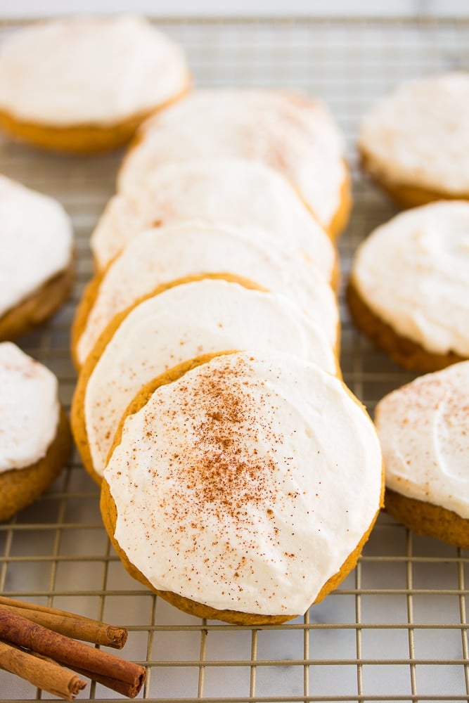 lined up pumpkin cookies on a cooling rack.