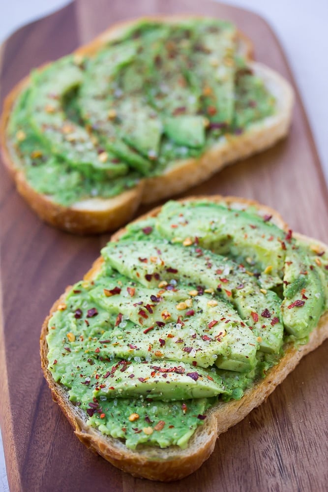 whole avocado toast sprinkled with salt and red pepper flakes.