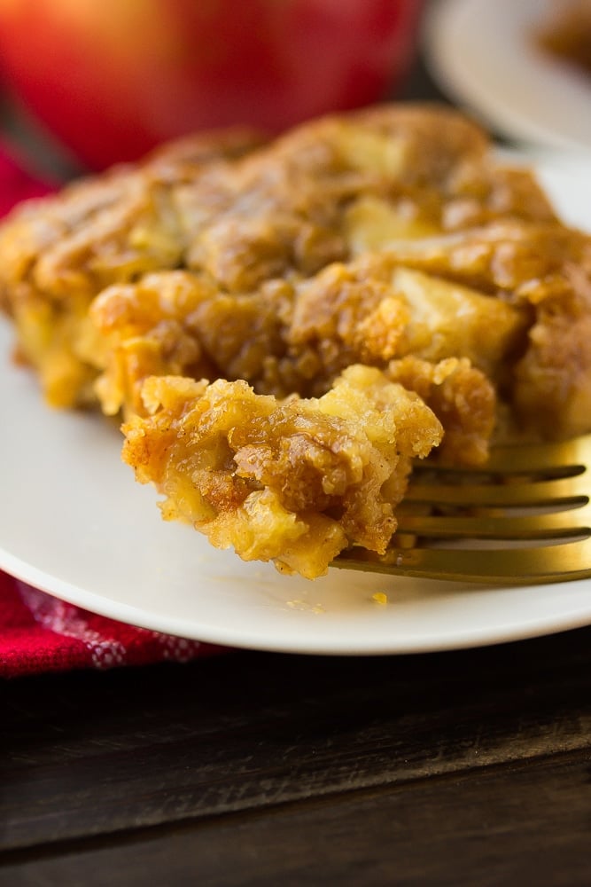 vegan apple cake with a fork taking a bite, red towel in background