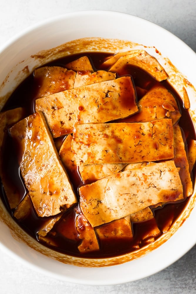 tofu marinating in a white bowl