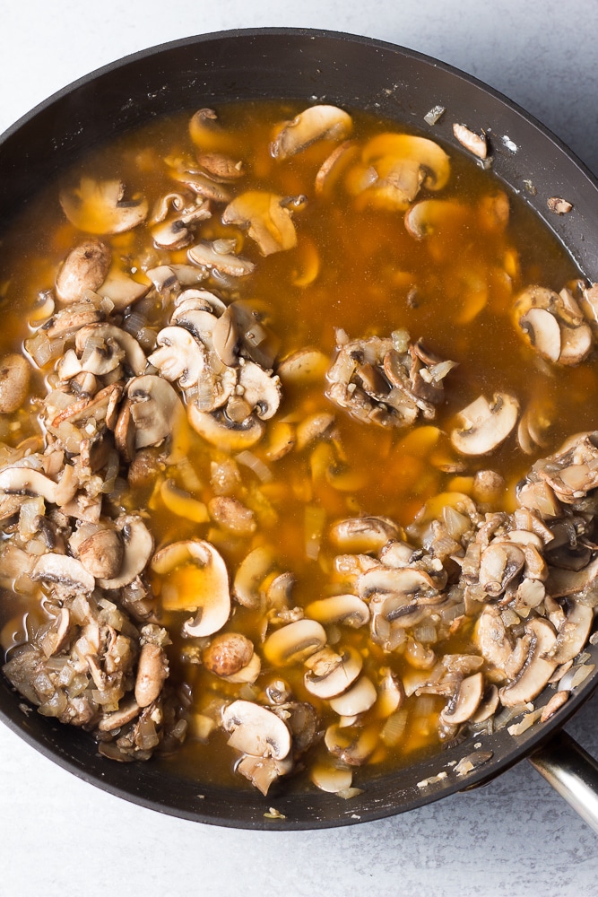 mushrooms cooked in pan with broth added